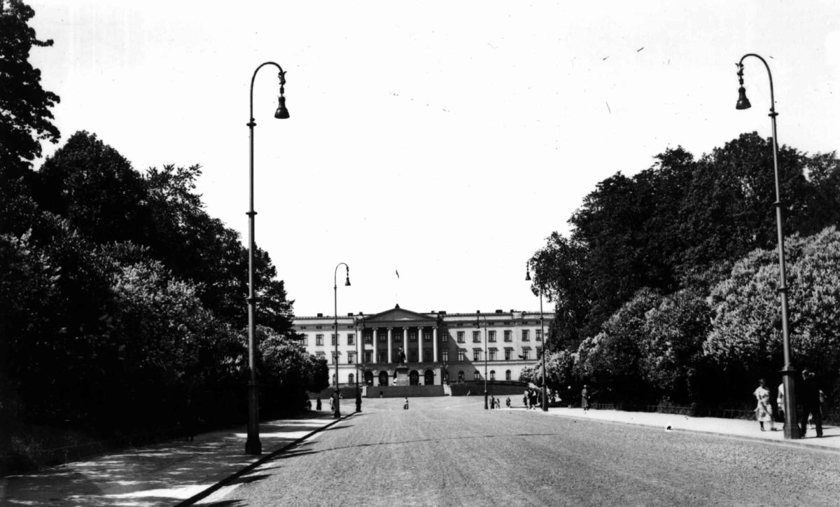 Slottet, Drammensveien 1, Oslo 1934. Slottet og Slottsplassen sett fra Karl Johans gate. Busker og trær langs gaten. Fotgjengere.