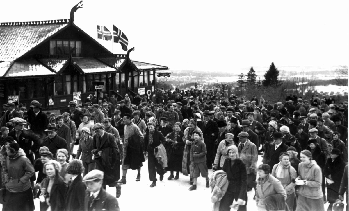 Ski. Holmenkollen, Oslo 1934. Hopprenn. Publikum ved Holmenkollen Restaurant på vei til hoppbakken. 