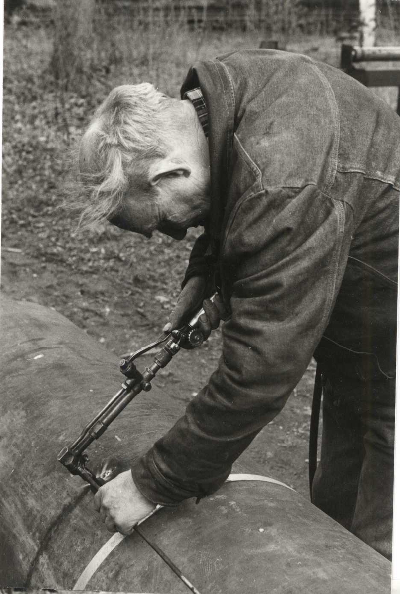 Martin Haugan i smia skjærer av et stålrør med skjærebrenner. Norsk Folkemuseum i april 1989.