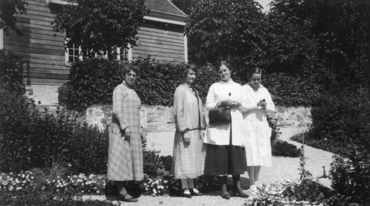 Noen av de kvinnelige ansatte er samlet i prestegårdshagen i 1929.
Prestegården, bygning nr. 191 på Norsk Folkemuseum, sees i bakgrunnen. 