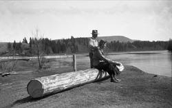 Dordi Arentz sitter på en tømmerstokk ved Lågen og hennes ma
