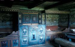 Interiør fra Mjålandsstova i Mandal, med rikt dekorert senge