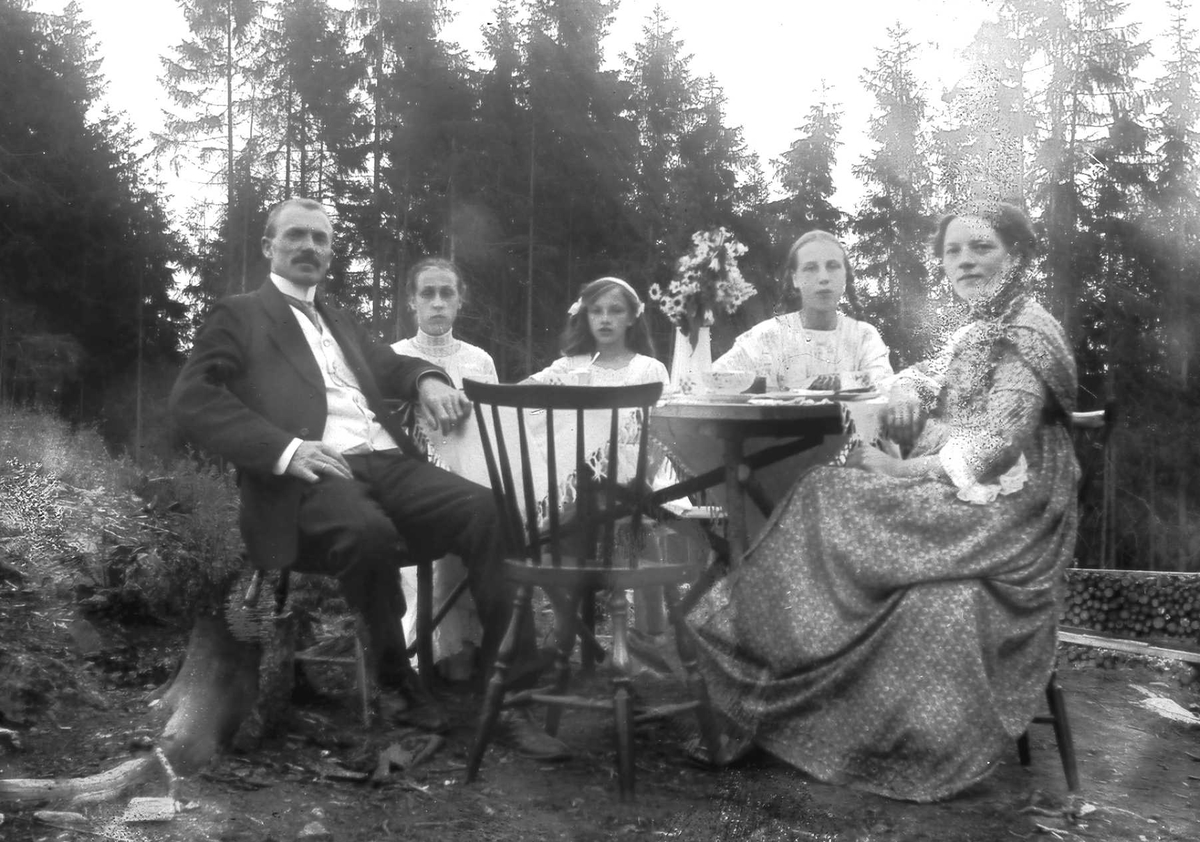 Fire kvinner og en mann sittende rundt bord på tomta i Ringstabekkveien.