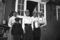 Fire kvinner og en gutt står oppstilt utenfor et inngangspar