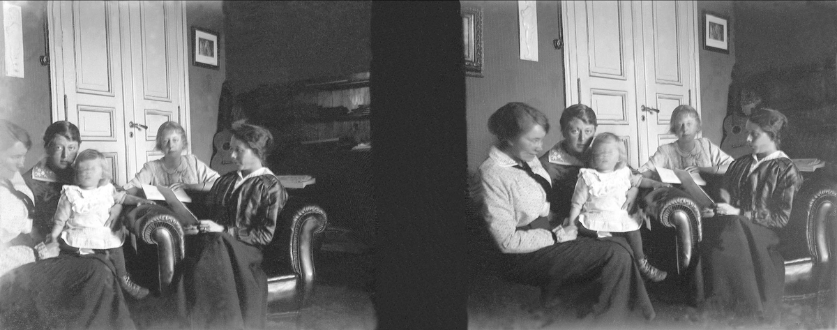 Stereoskopi av en gruppe mennesker som sitter i en stue. Robsahm og Lund.