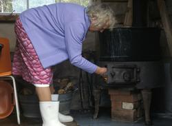 Inga Enodd fyrer i kjelringen i kokehuset på Endal seter.
K