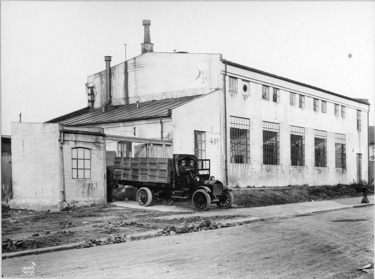 Tiedemanns eskefabrikk på Bergensgate. En lastebil med kasser er på vei ut av fabrikken.