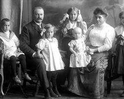 Gruppeportrett, familiebilde, ektepar med fem barn. Kjøpmann