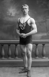 Portrett, bryter, med drakt og medaljer. Herbrand Lofthus. I