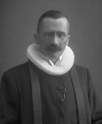 Portrett, mann i prestekjole og krage.