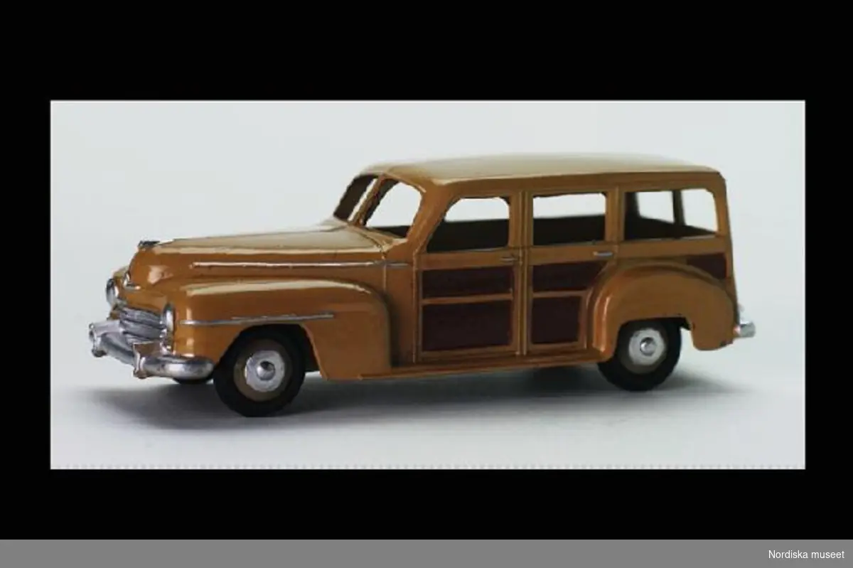 Inventering Sesam 1996-1999:
L 10,5  H 3,5 B 3,5 (cm)
Gulbrun stationsvagn av gjuten metall. Svarta gummidäck med profilerade navkapslar. Saknar inredning och fönsterrutor.
Underredet märkt "DINKY TOYS/ MADE IN ENGLAND/ MECCANO LTD"  Modell Plymouth 1946.
Bilen är en sk "Woody" där stora delar av karossen är tillverkad av trä. "Woodies" var populära i USA framförallt efter II:a världskriget. Enligt bilaga inköpt 29/11 1950 av givaren för 2,75 på PUB, Stockholm. Givaren samlare av leksaksbilar 1947-1952, se inv.nr. 263.905 - 264.120.
Bilaga.
Birigtta Martinius 1996