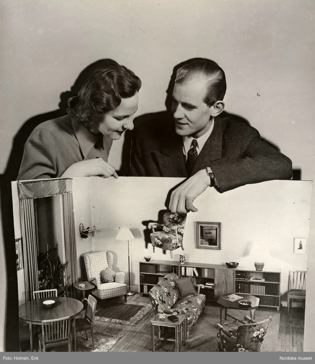 Utställningen Brud och hem på varuhuset Nordiska Kompaniet i Stockholm 1944. Man och kvinna med modell av en möblerad lägenhet.