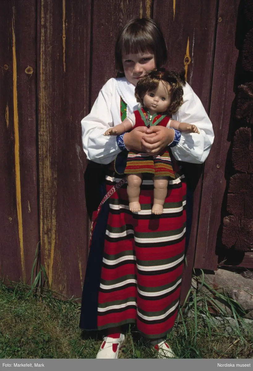 Rättvik, Dalarna. Midsommarafton. Flickan Elin med dockan Hosianna, båda klädda i Rättviksdräkt.