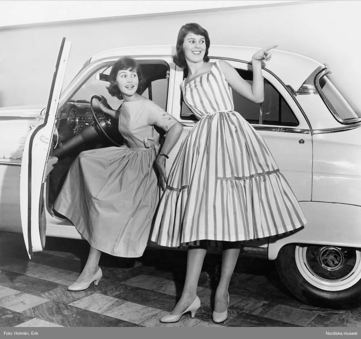 Tonårsmode, Nordiska Kompaniet. Två modeller i klänningar vid bil.