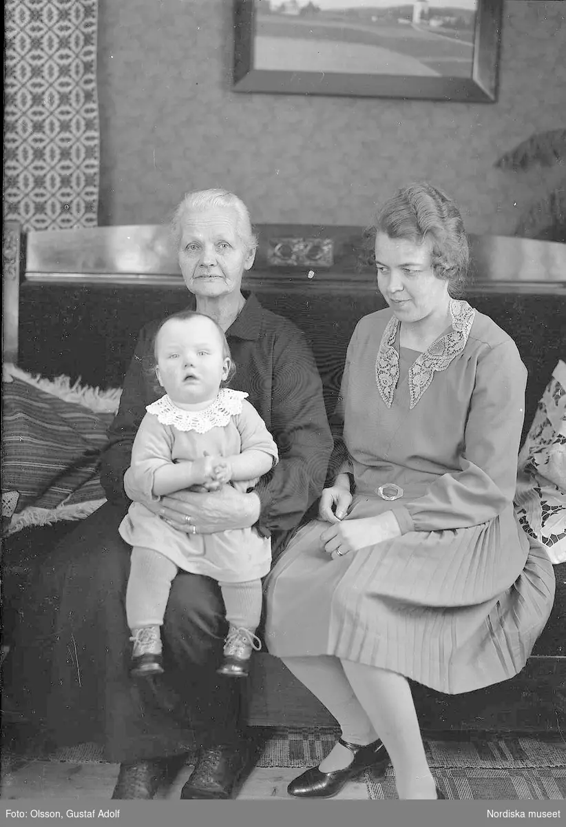 Porträtt av två kvinnor med ett litet barn i interiör från 1900-talets första hälft.