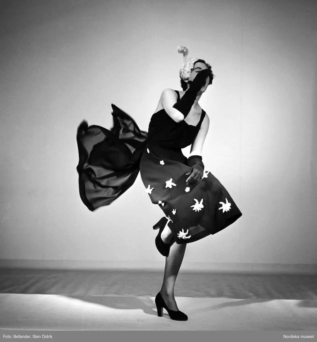 Straw and chiffon är fotografens titel på studiofotot från 1950 där en livligt poserande modell visar klänning från varuhuset MEA. Bilden publicerades även som omslagsbild på Svensk Fotografisk Tidskrift.