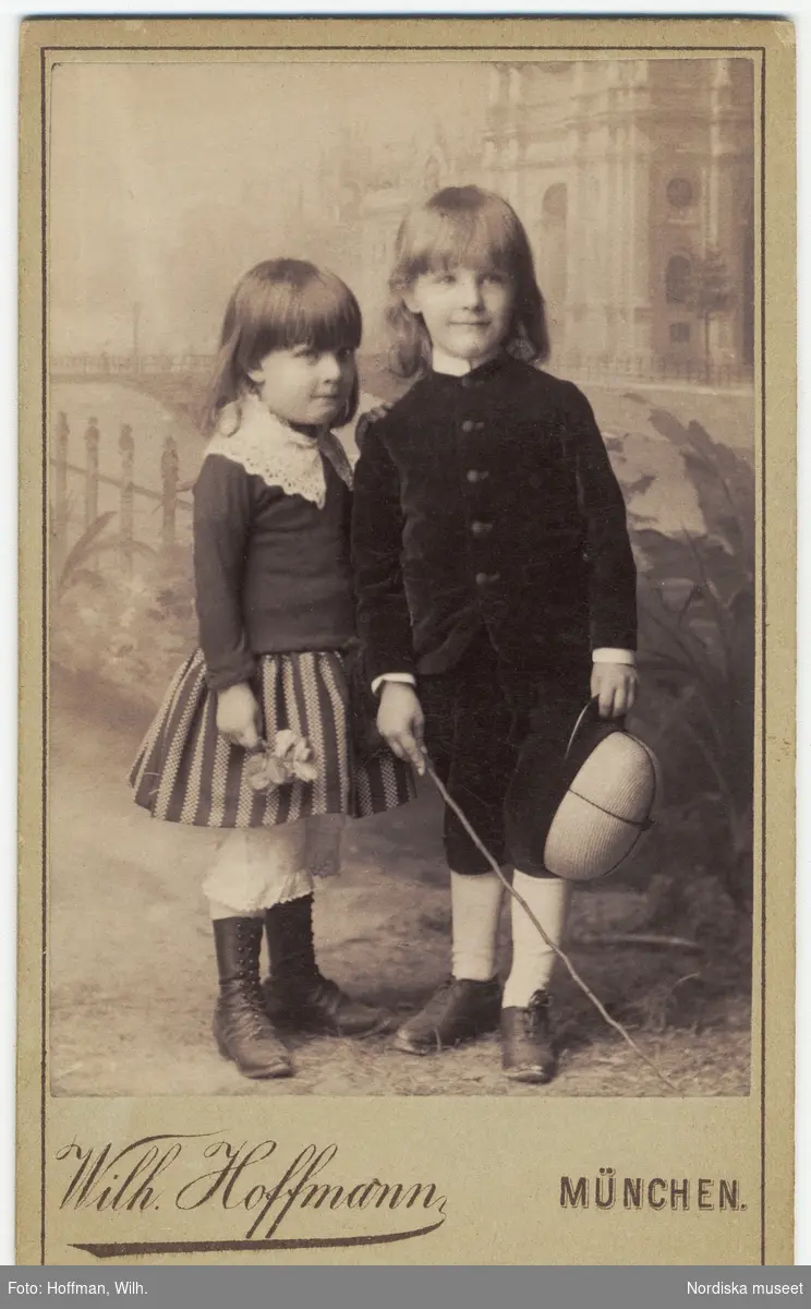 Ateljéporträtt av två barn, en pojke och en flicka. På baksidan påskrift med blyerts april 1888.