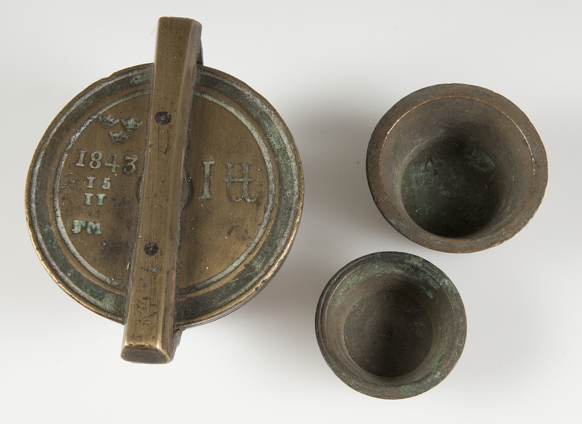 Ett skålpund med två insatser. Stämplar på locket: tre kronor 1843 TM.
Stämplar på undersidan: fem kronor. Flera insatser saknas.
 
