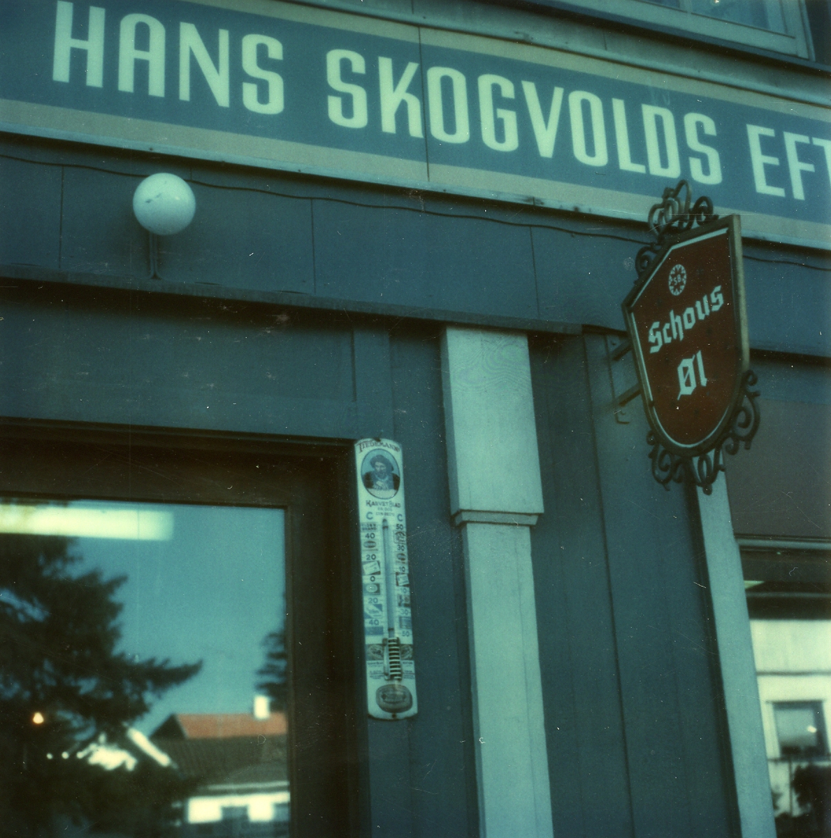Reklameskilt og termometer utenfor forretningen Hans Skogvold Eftf.