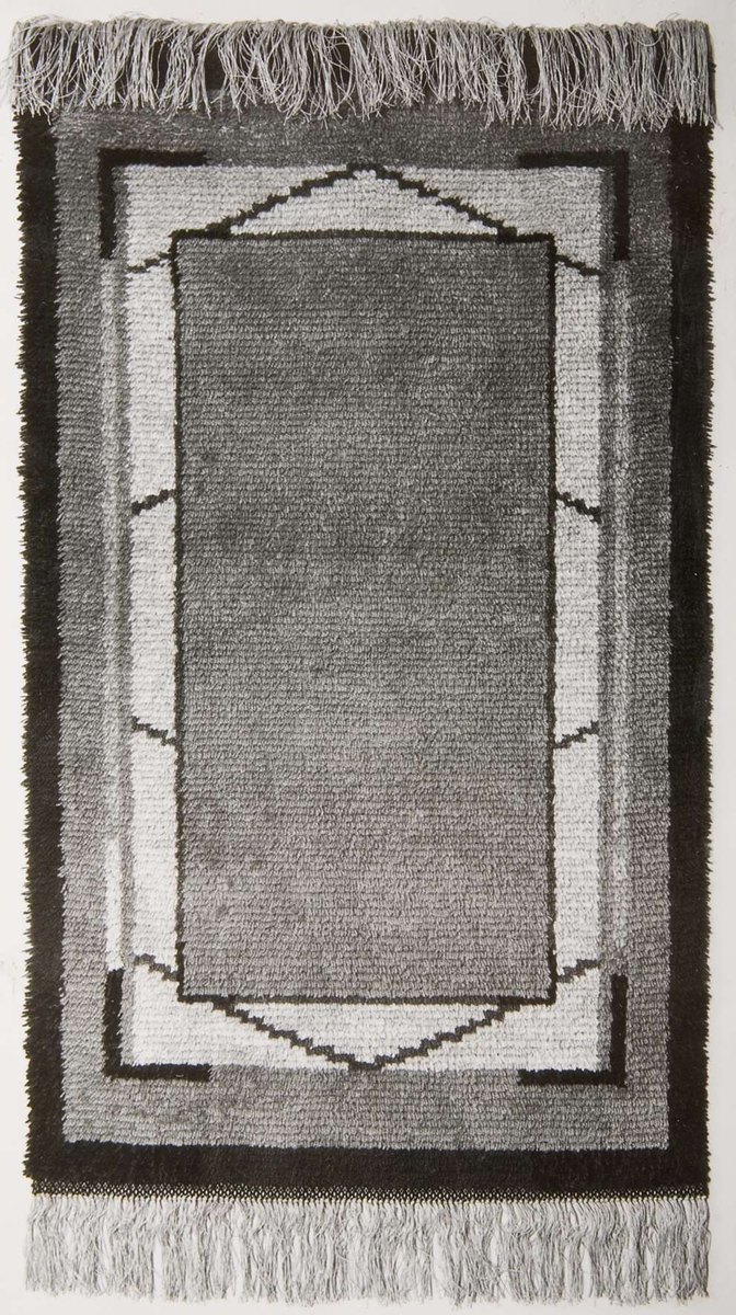 Tre svartvita fotografier föreställande mattor. Fotografierna är klistrade på 22 x 27 cm stora bruna kartongblad.