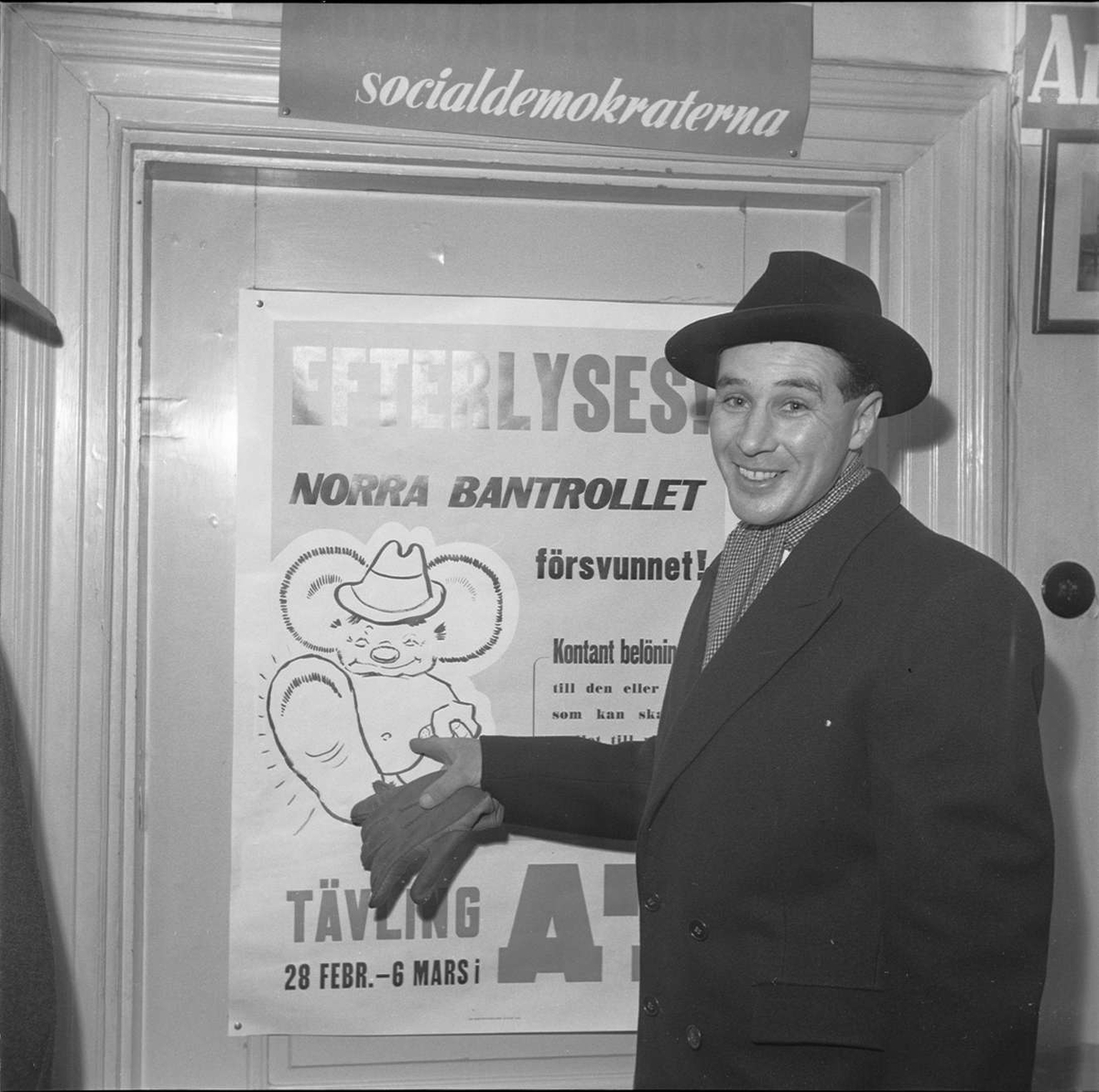 Man framför affisch om tävling gällande Norra Bantrollet, Aftontidningen, sannolikt Uppsala 1949