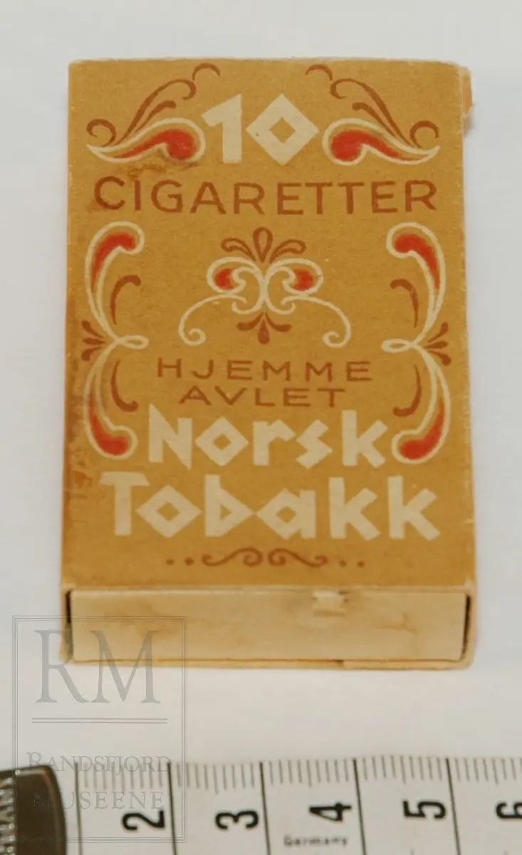 7 sigaretter - tobakk rullet inn i hvitt papir med påtrykt lite rødt merke. Eske av tynn papp i to deler. 