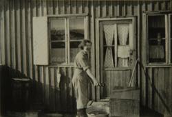 Kvinne utenfor et hus