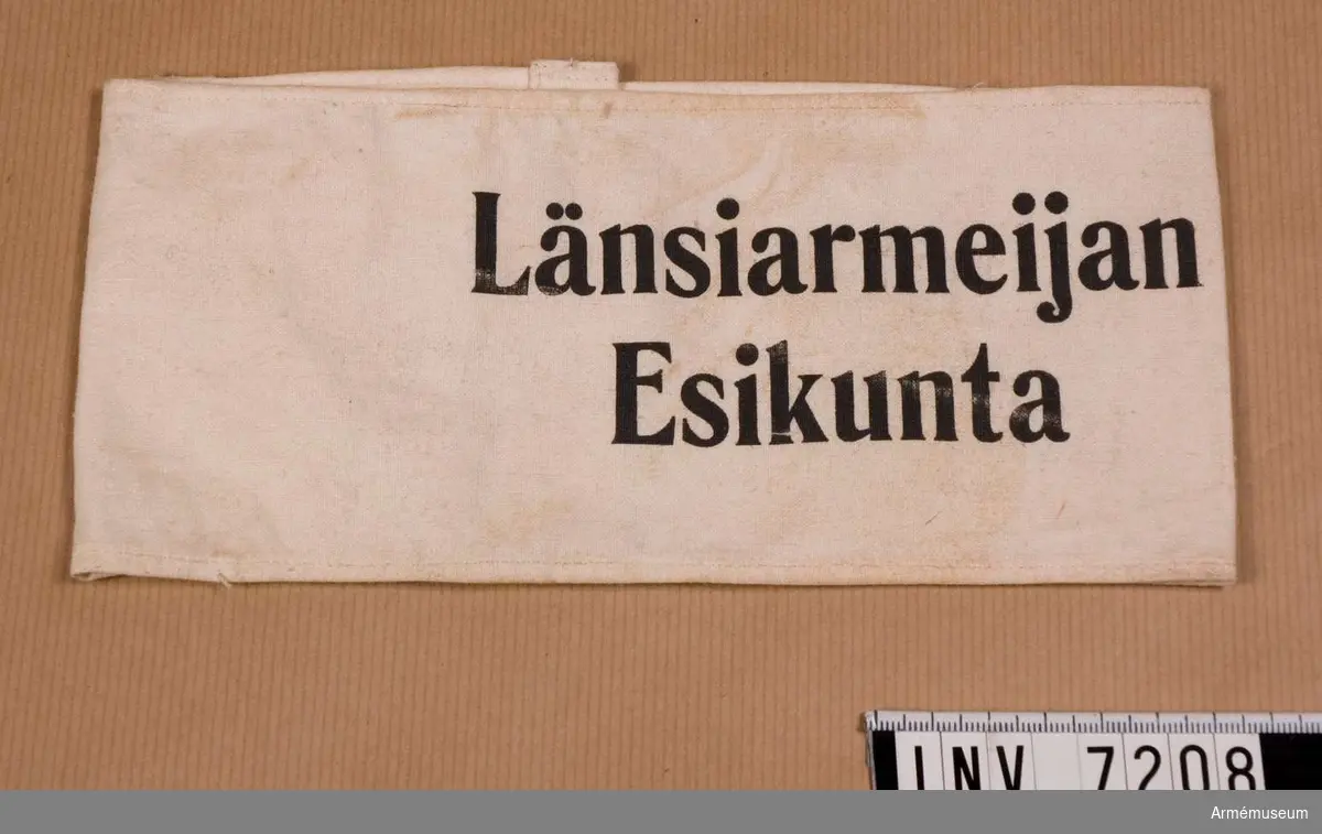 Av vit bomullsväv med i svart tryck texten: Länsiarmeijan  Esikunta.