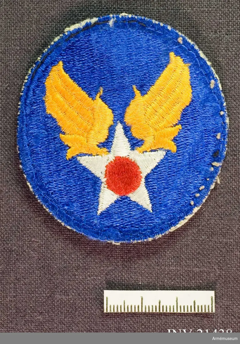 Samhörande gåva: 21437-51, 22351-2, uniformsemblem.Emblem, United States Army Air Force, USAAF.
Grupp C I.
För amerikansk trupp som deltog i striderna i Korea 1950-53.
US Army Air Force. Fram till 1948 hade USA icke något självständigt flygvapen. Det var uppdelat på vapengrenarna.