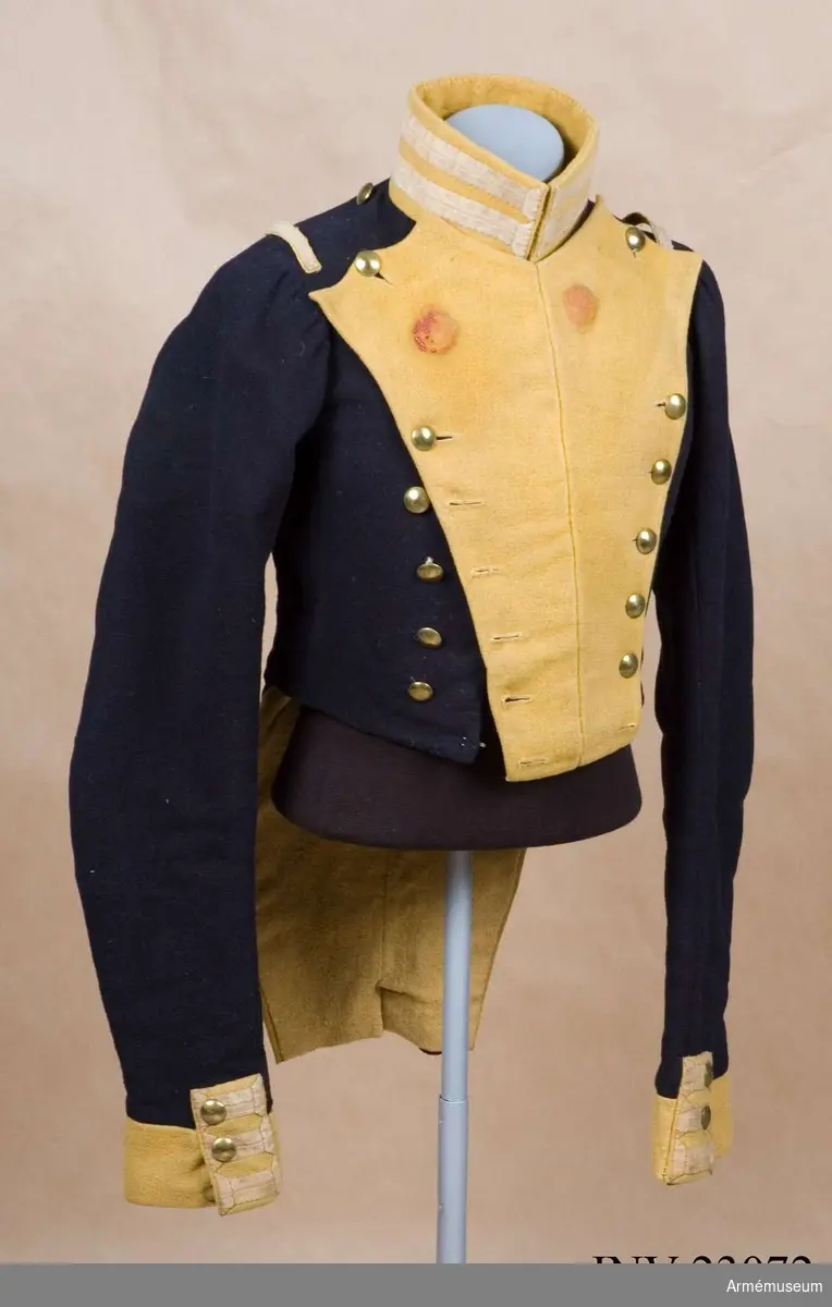 Grupp C I.
Frack av mörkblått kläde med gul bröstrevär, gula ärmuppslag och gul krage, försedd med vita redgarnsband.