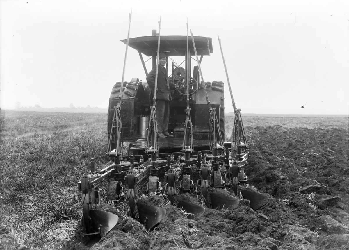 Plöjning vid Nyckelby gård, Övergrans socken, Uppland, 18 maj 1911. Traktorn som syns är enligt uppgift en av de allra första sålda i Sverige.