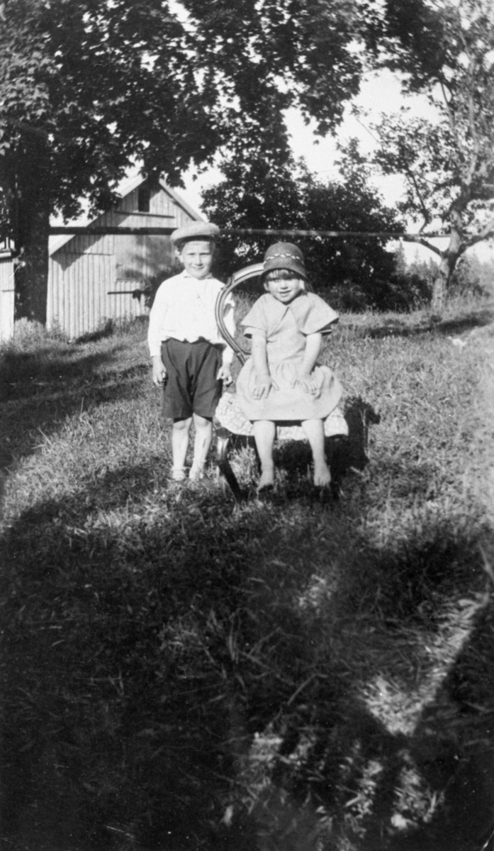 Två barn i trädgård i Kärra.