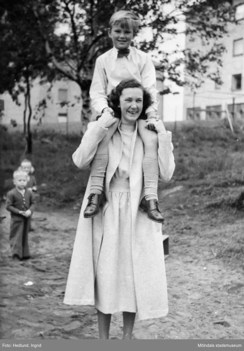 Guldheden 1945-. En pojke sitter på axlarna på en fröken.