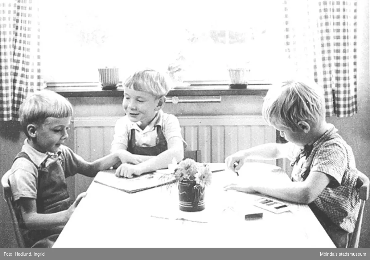Daghem i Guldheden, Göteborg. Tre pojkar som pysslar vid ett bord. Bilden är tagen på sent 1940-tal.