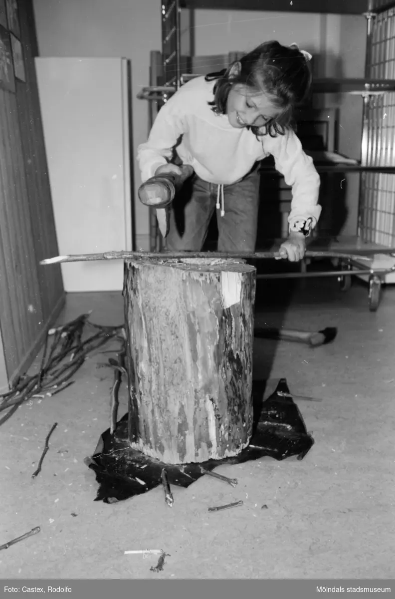 En flicka borrar med en borr i en träpinne. Utställningsvernissage av och om Katrinebergs daghem på Mölndals museum 1993-09-10.
