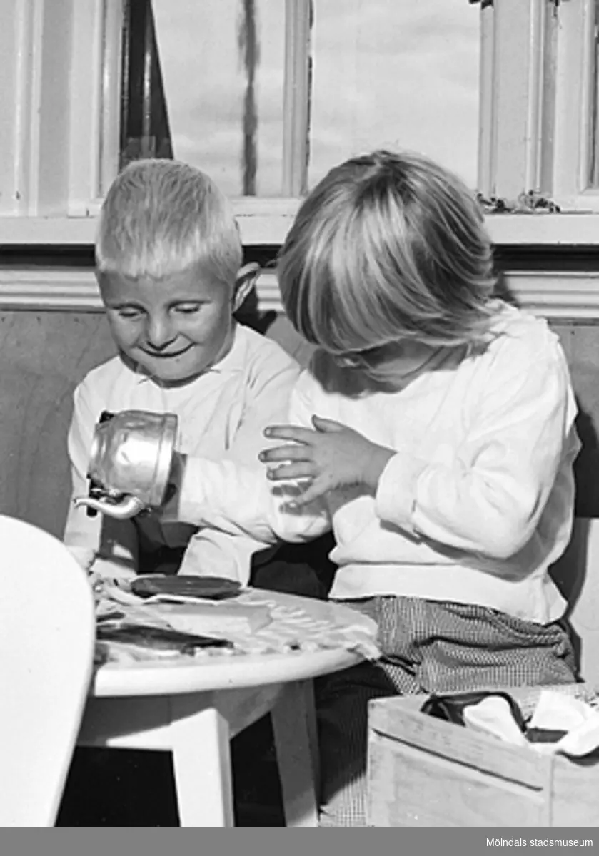 Två barn leker vid ett "kaffebord". Holtermanska daghemmet 1953.