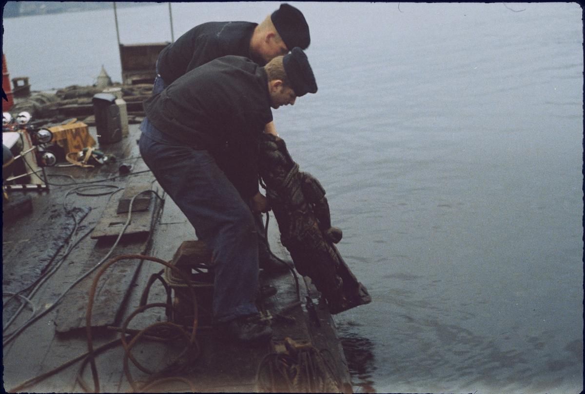 Dykare får upp en skulptur från Vasa på dykarflotten.