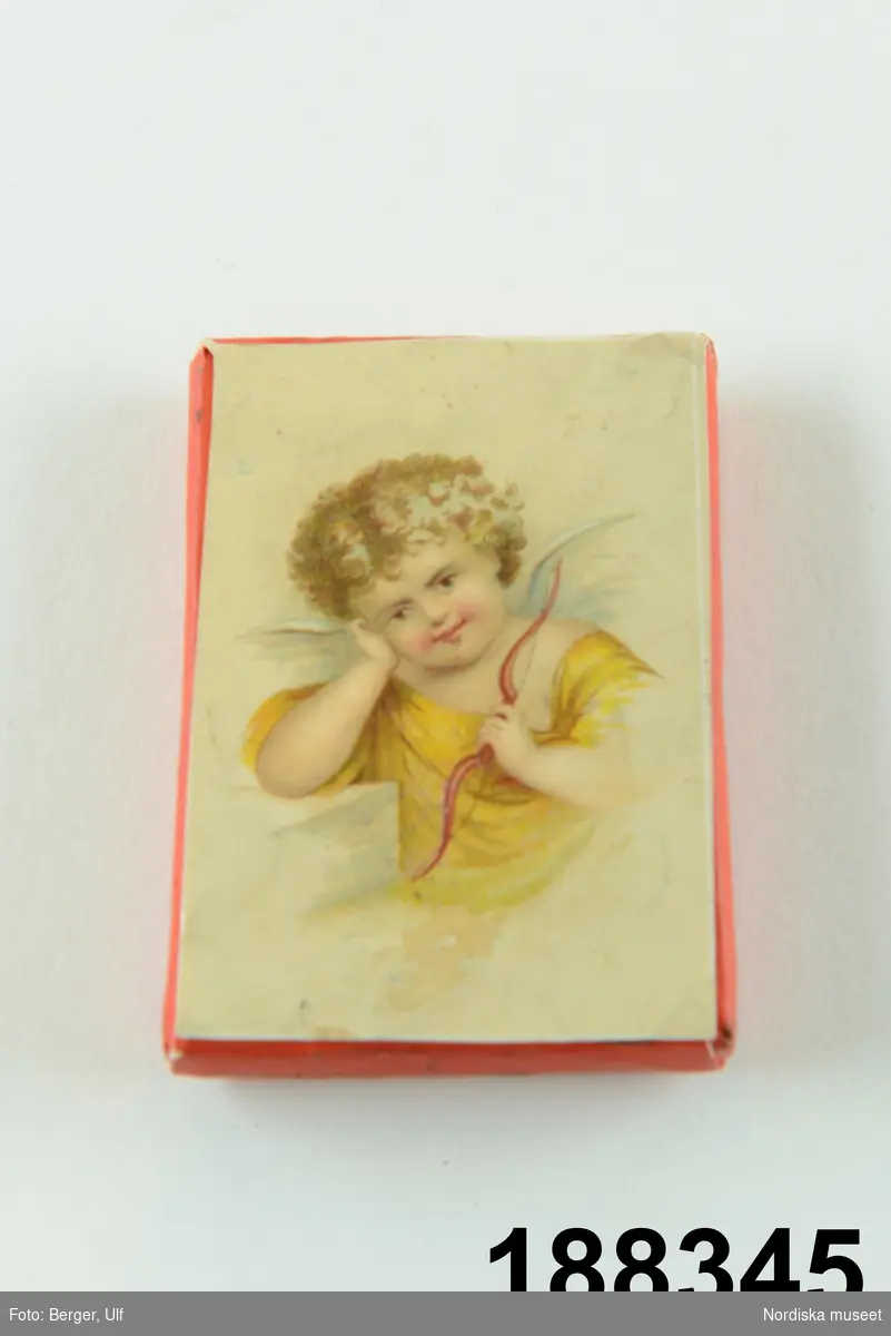 Huvudliggaren:
"Papperskaramell, rekt. karamell  i rött papper med bild av amor med båge, fr. Landelius. Gåva 30/12 1912 av Fröken Maria Arosenius, Sthlm."
