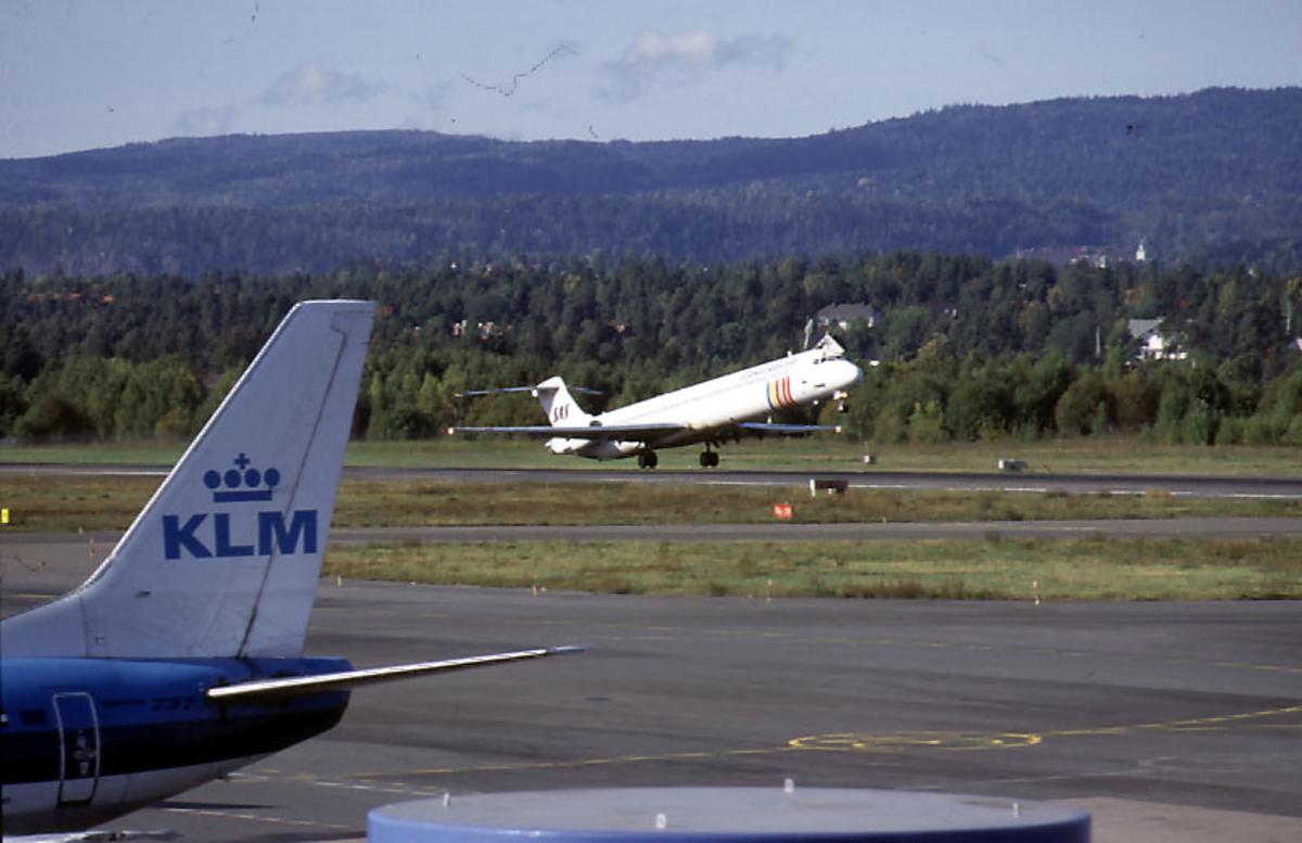 Lufthavn, 1 fly i ferd med å ta av, MD-82, SE-DFS "Bjørn Viking" fra SAS.  Halepartiet på 1 fly fra KLM i forgrunnen.