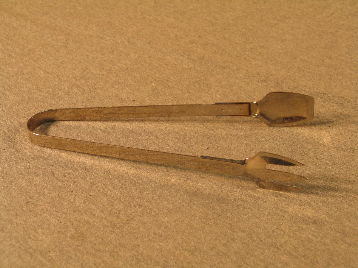 Bøygd stålbøyle som er påsett ein gaffel på ein arm og skei på andre.