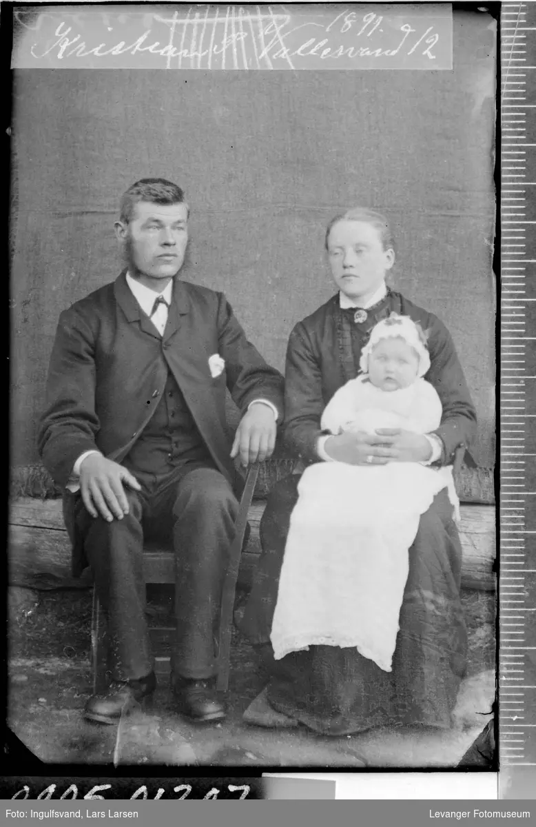 Portrett av en kvinne, en mann og et barn i dåpskjole.