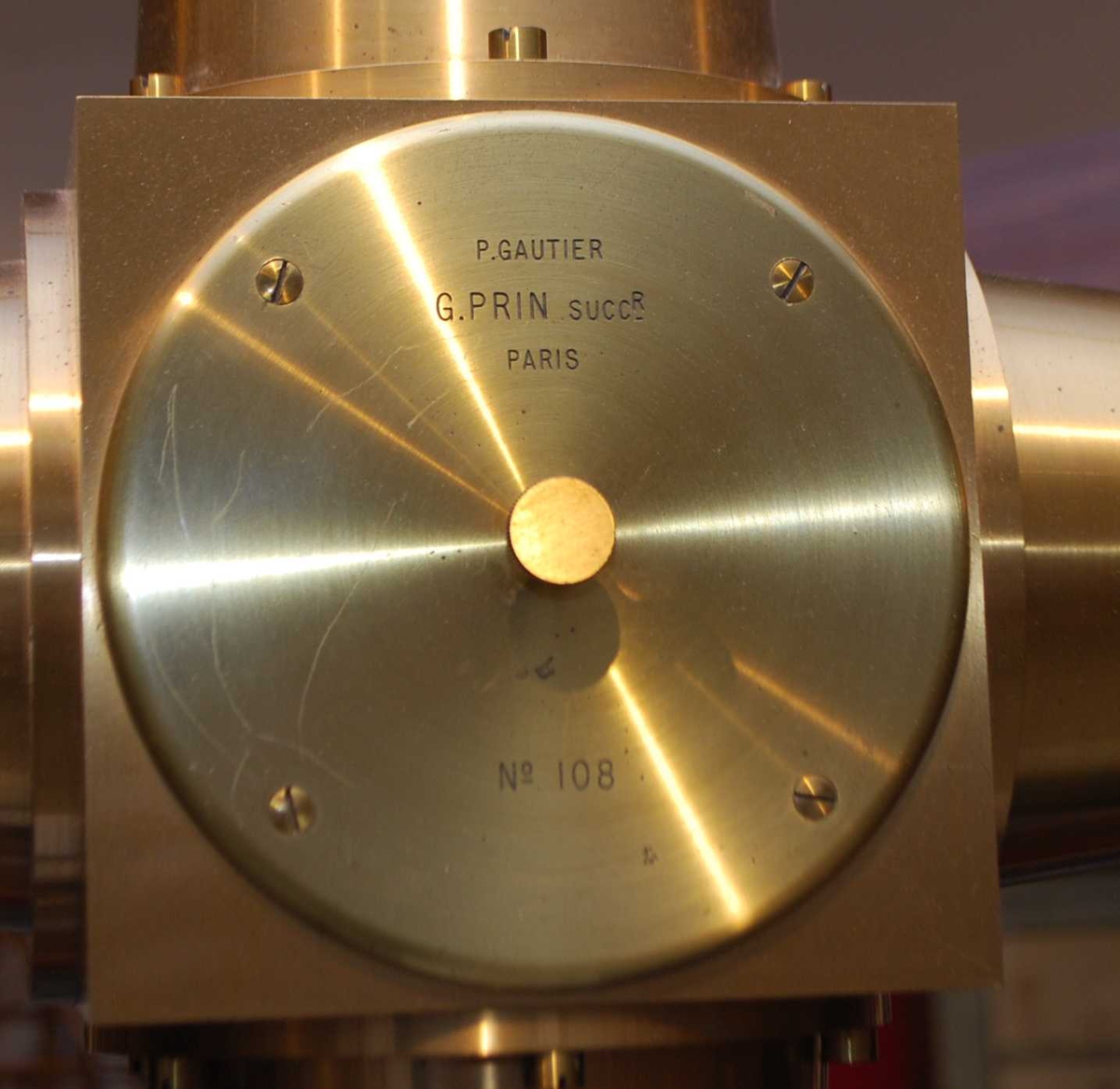 Instrumentet har upersonlig mikrometer og motordrevet filament. På sidene er brytere for motor, lys og kronometer