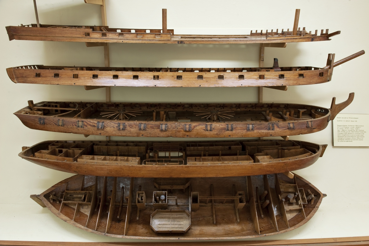 Fartygsmodell, undervisningsmodell, av origgat linjeskepp. Modellen är byggd i sex horisontella plan och har portar för 74 kanoner.