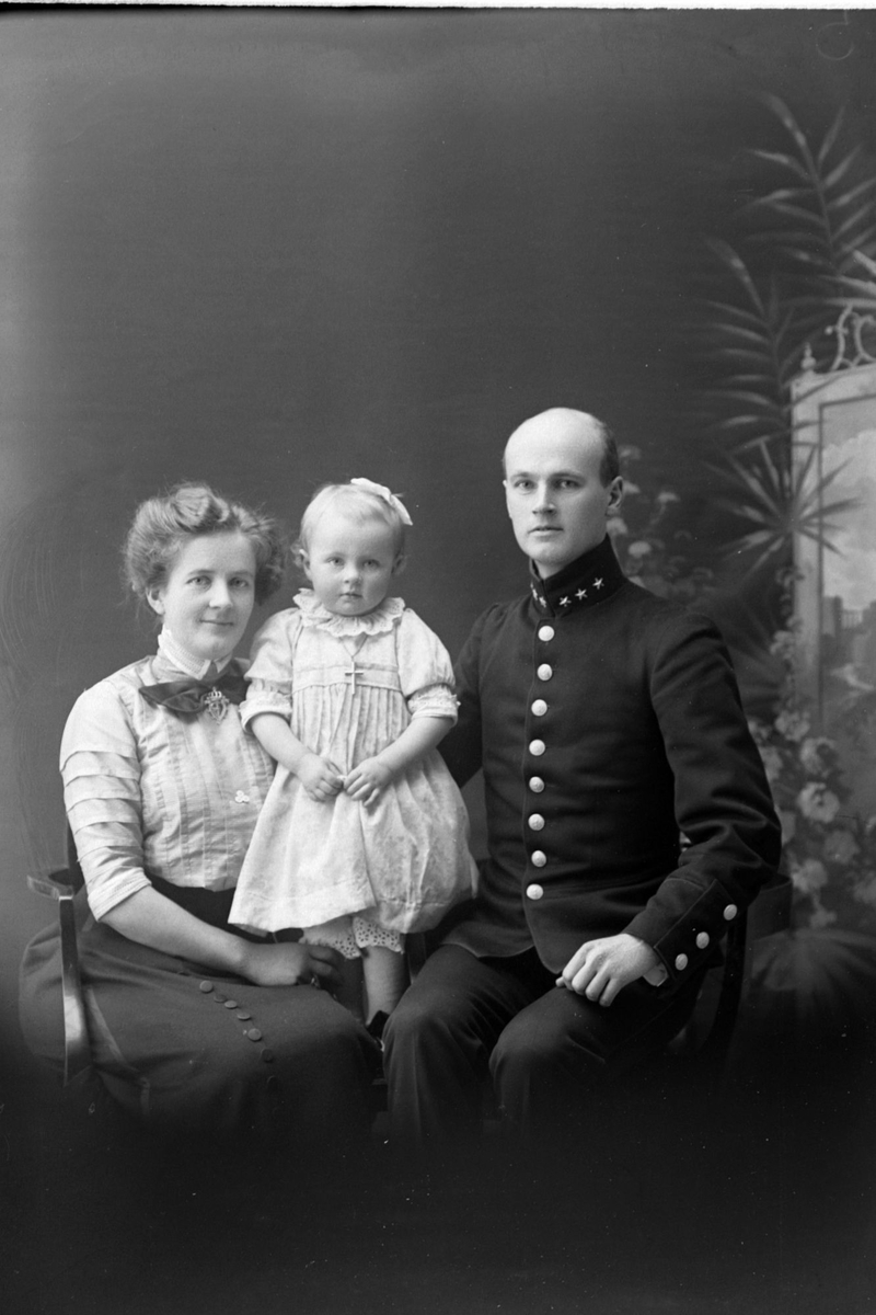 Studioportrett av en mann i uniform ved siden av en kvinne og et barn.