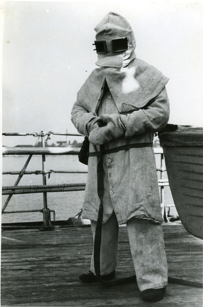 Jungman i asbestdräkt under eldsläckningsövning ombord på pansarskeppet OSCAR II.