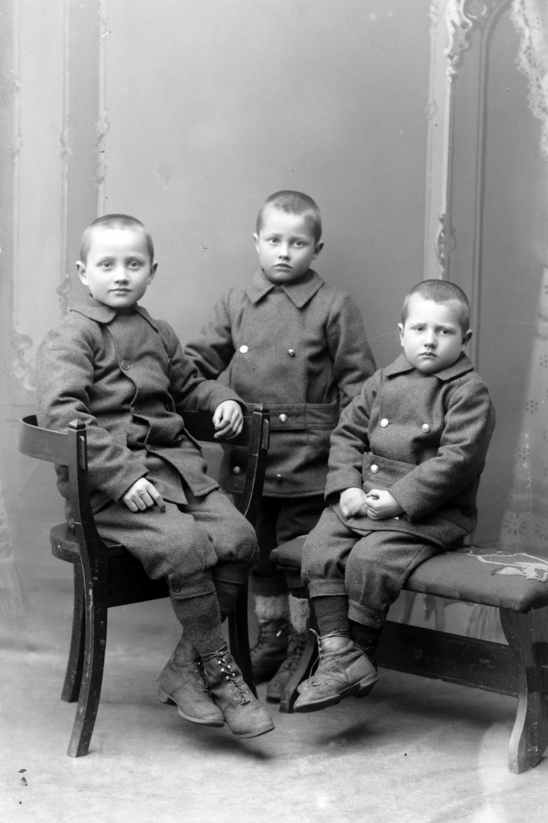 Studioportrett av tre unge gutter.