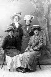 Studioportrett av fire kvinner i helfigur.