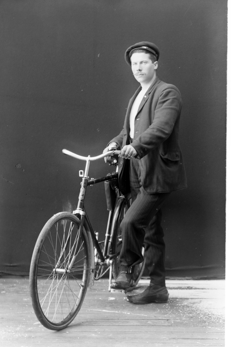 Studioportrett av en mann med en sykkel.