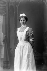 Studioportrett av en sykesøster i uniform.