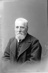 Studioportrett i halvfigur av en eldre mann.